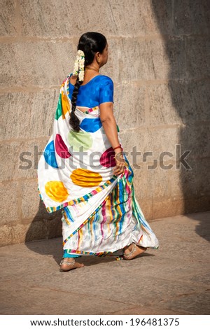 MADURAI, INDIA - FEBR 16: Unidentified indian woman in traditional colorful sari and bangles going to Hindu religious ceremony at Meenakshi Temple on Febr 16, 2013. India, Madurai, Tamil Nadu