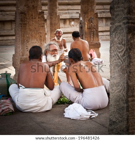 MADURAI, INDIA - FEBR 16: Hindu Brahmin with religious attributes providing ceremony and blessing pilgrim at holy place for hindu people Meenakshi Temple on Febr 16, 2013. India, Madurai, Tamil Nadu