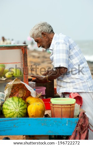 PONDICHERRY, INDIA - FEBRUARY 12: Indian man selling fruits at beach market on February 12, 2013 in Pondicherry, India. Lot of vegetables and fruits important ingredients of traditional Indian food