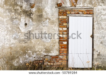 Plastic door with old rust doorlock at old, damaged grunge wall