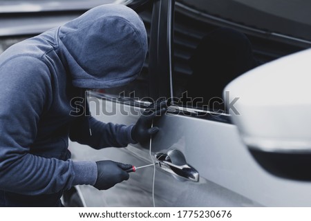 Close up car thief hand holding screwdriver tamper yank and glove black stealing automobile trying door handle to see if vehicle is unlocked  trying to break into inside.  Foto stock © 