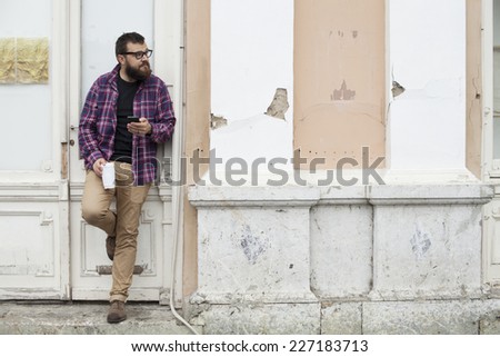 Man With Beard And Glasses Holding To Go Cup And Mobile Smart Phone