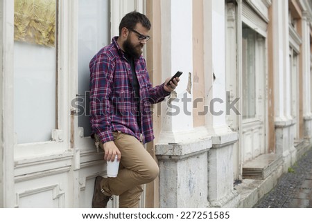 Man With Beard And Glasses Holding Phone And To Go Cup