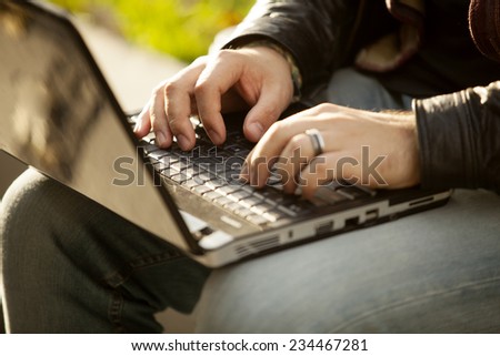 Man Typing On Laptop Computer Outdoor