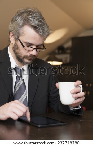 Business Man At Home Using A Laptop Computer And Drinking Coffee