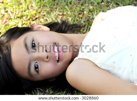 Eight Year Old Asian Child Lying on the Grass