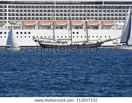 traditional sailing ship meets huge modern cruise ship