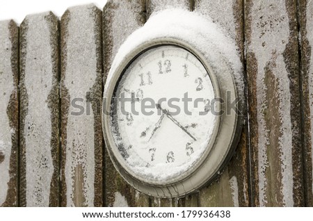 frozen clock on cedar fence