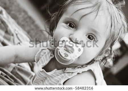 A little girl with a pacifier .