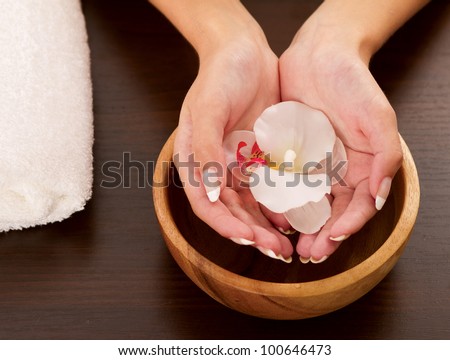 Woman\'s hands holding flower on bowl of water