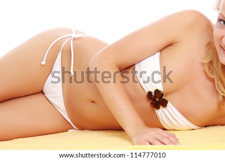 A part of a female body in a white swimsuit lying on a yellow towel