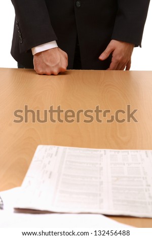 Unknown businessman standing near desk  with documents