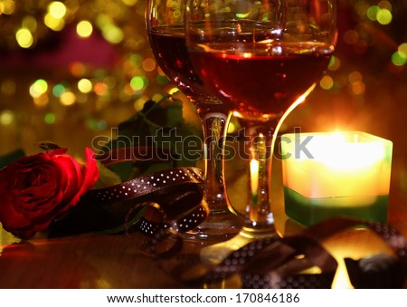 christmass dinner with rose candies and two glasses of red wine