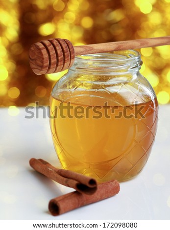 Honey with wood stick and cinnamon sticks