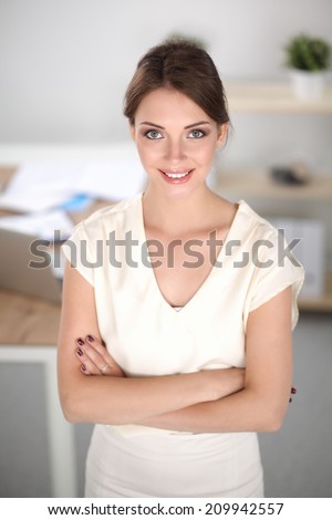 Close-up portrait of a smiling  business woman standing in her office