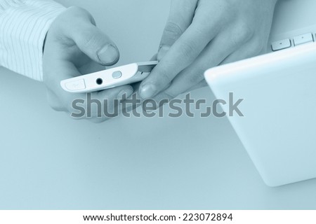 Male hands holding a mobile phone, from above