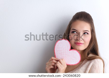 Portrait of beautiful happy woman holding a Valentine day symbol.