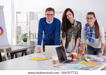 Young business people standing at office near desk.