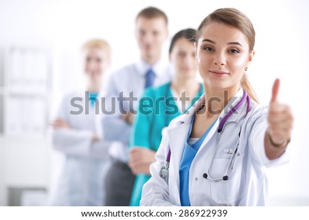 Attractive female doctor in front of medical group .