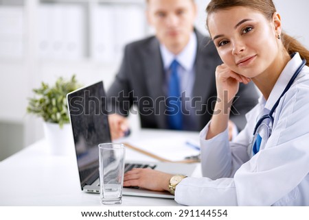 Medical team sitting at the table in modern hospital .