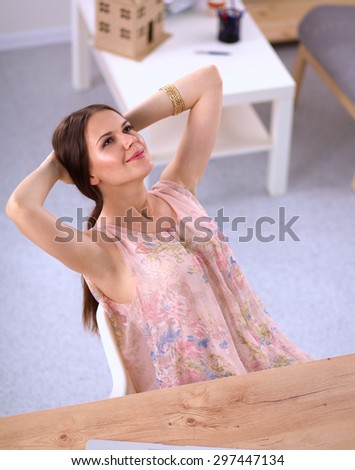 Business woman relaxing with her hands behind her head and sitting on a chair.