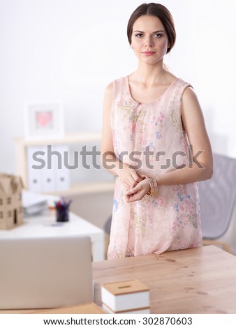Close-up portrait of a smiling business woman standing in her office.