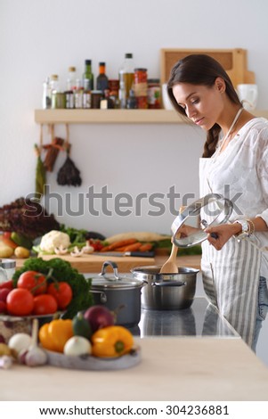 Cooking woman in kitchen with wooden spoon.