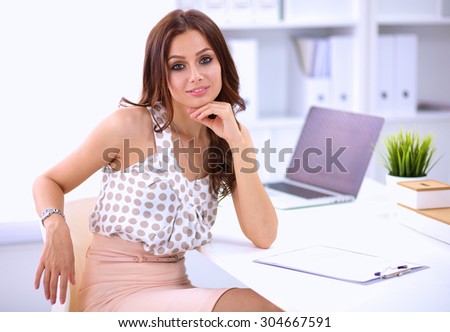 Portrait of beautiful young business woman working on a laptop.