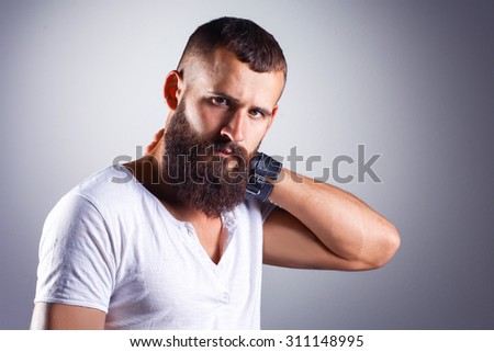 Portrait of handsome bearded man standing, isolated on grey background
