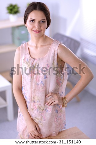 Close-up portrait of a smiling business woman standing in her office