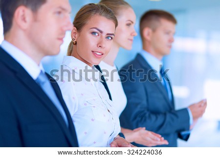 Smiling business people applauding a good presentation in the office