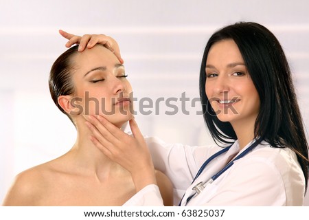 Pretty doctor examining beautiful young female\'s face