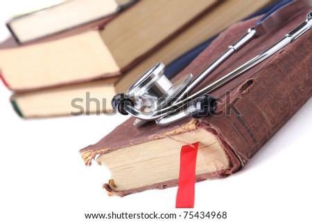 A stethoscope on a book with a red bookmark near a pile of books