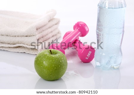 Water, apple, towel and dumbells isolated on white background