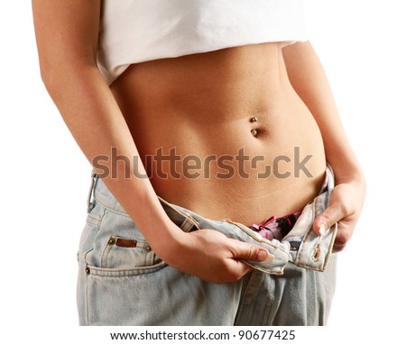 Beautiful smiling woman showing how much weight she lost - Isolated on white