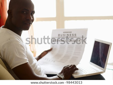 Portrait of an African American with newspaper and laptop