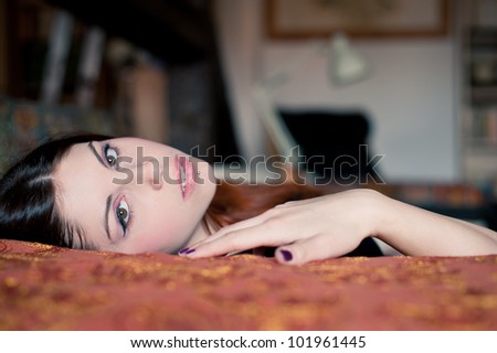 Portrait of a sensual young woman lying on sofa. Shallow depth of field.