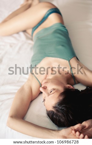 Portrait of a sensual woman lying on bed. Shallow depth of field.