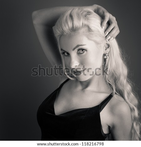 Beautiful blonde woman close up portrait against dark background. Sepia tone image.
