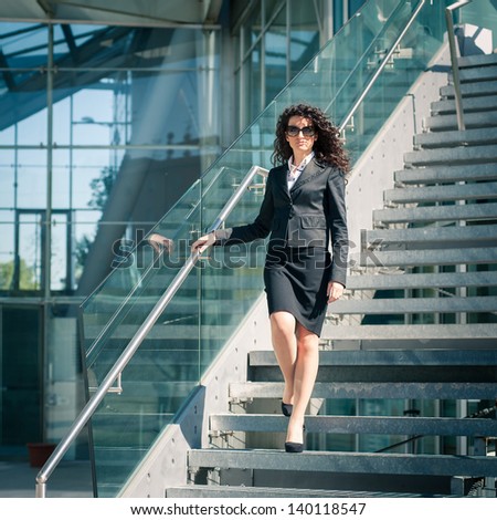 Business woman portrait outdoors with modern building as background. Full body.