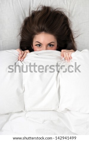 Portrait Of A Young Woman Lying In Bed Hiding Under Duvet. Stock Photo ...