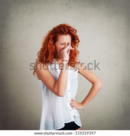 Yawning redhead woman portrait against grunge background.