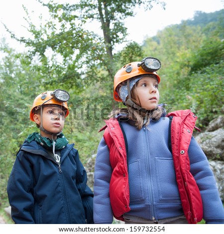 Young kids wearing helmet for cave exploration.