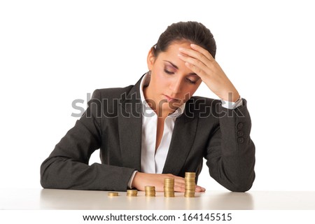 Worried businesswoman with stacks coins against white background