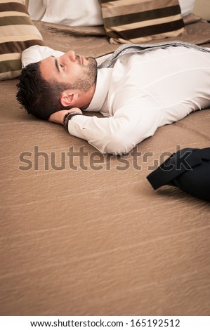 Young businessman relaxing in hotel room.