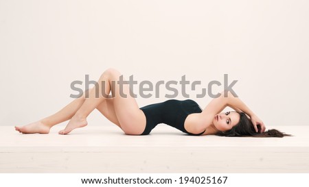 Sensual woman portrait laying on table with black underwear. Full body portrait.