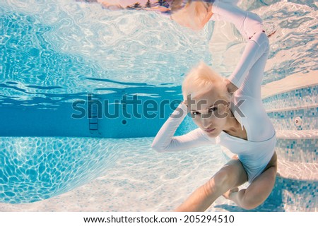 Beautiful woman wearing swimsuit underwater in swimming pool.