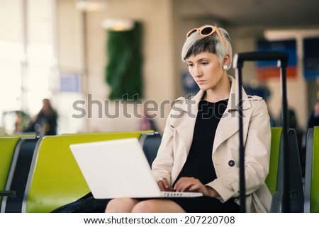 Businesswoman working with portable computer at Charles de Gaulle airport, Paris.