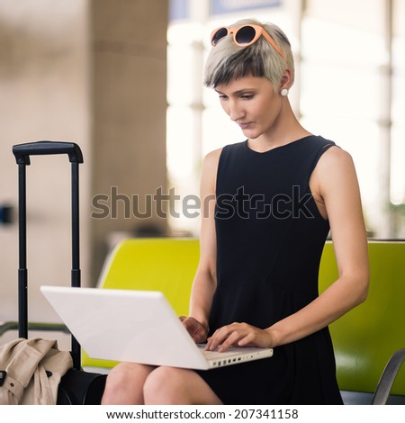 Businesswoman working with portable computer at Charles de Gaulle airport, Paris.