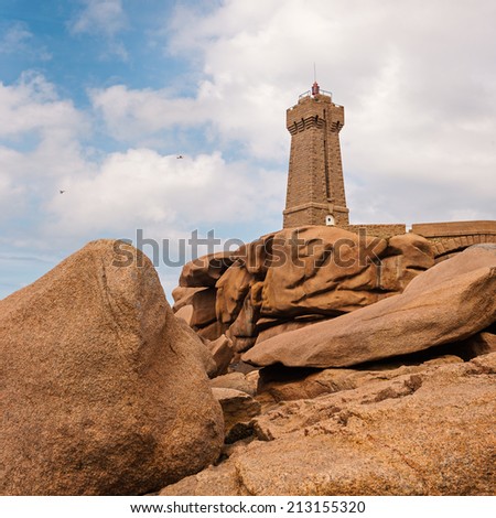Ploumanac\'h lighthouse against blue cloudy sky. It is an active lighthouse in Cotes-d\'Armor, France, located in Perros-Guirec. The structure is composed of pink granite.